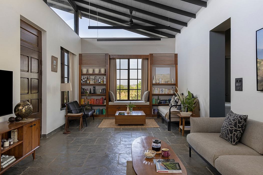A cozy and modern living room with a slate tile floor, wooden beams, and built-in shelving.