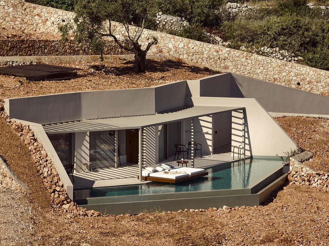 A modern, angular villa with a pool nestled in a rocky, wooded setting.