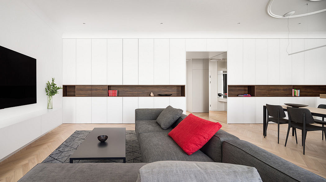 Minimalist living room with white walls, wood accents, and geometric furniture and rug.