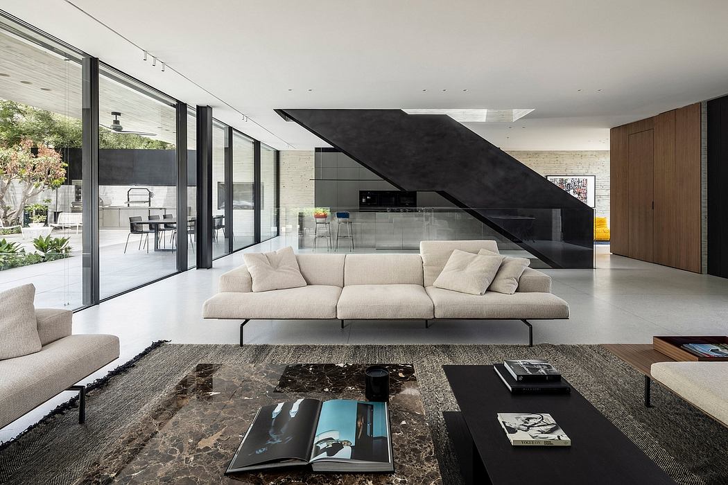 Expansive open-concept living space with large glass walls, modern furniture, and bold architectural elements.