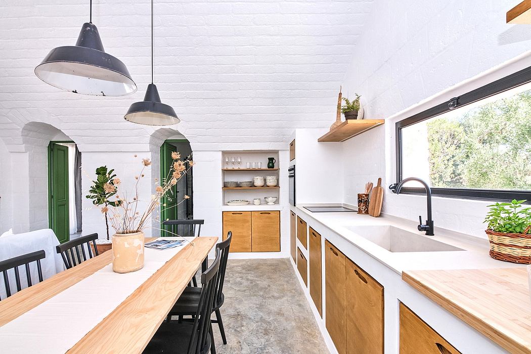 Bright, modern kitchen with wooden cabinets, pendant lights, and a large dining table.
