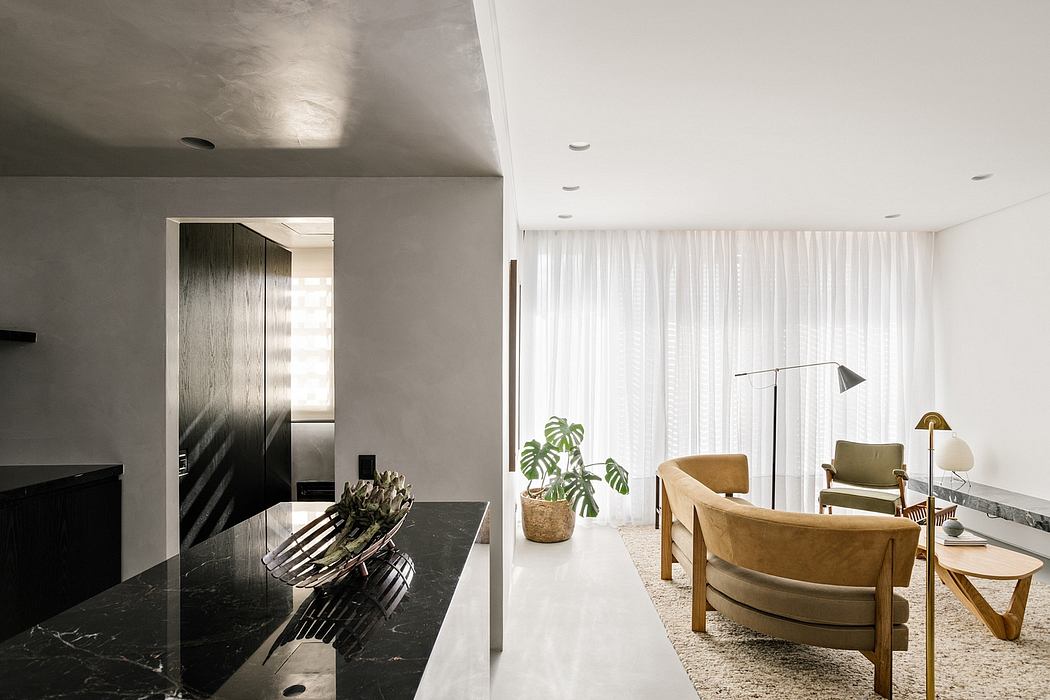 Sleek, minimalist interior with black marble surface, wood chairs, and potted plants.