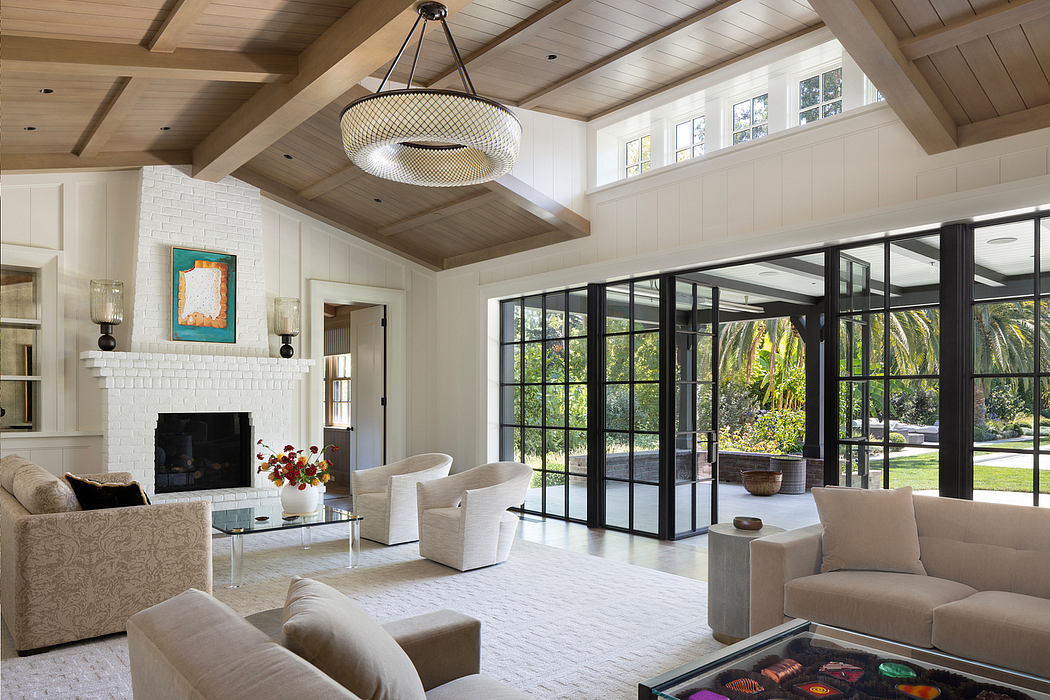 Spacious living room with vaulted ceilings, large windows, and a modern chandelier.