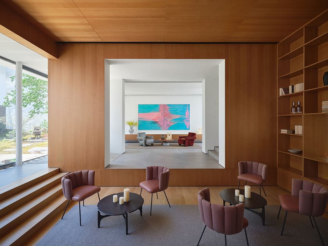 A spacious, modern living area with a large abstract painting, wood-paneled walls, and plush seating.