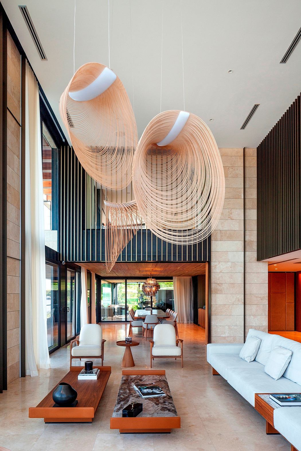 Lavish modern living space with sculptural light fixtures, sleek furnishings, and glass walls.