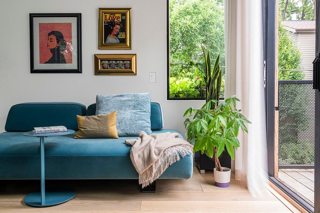 Cozy living room with teal sofa, potted plant, and framed artwork on the wall.