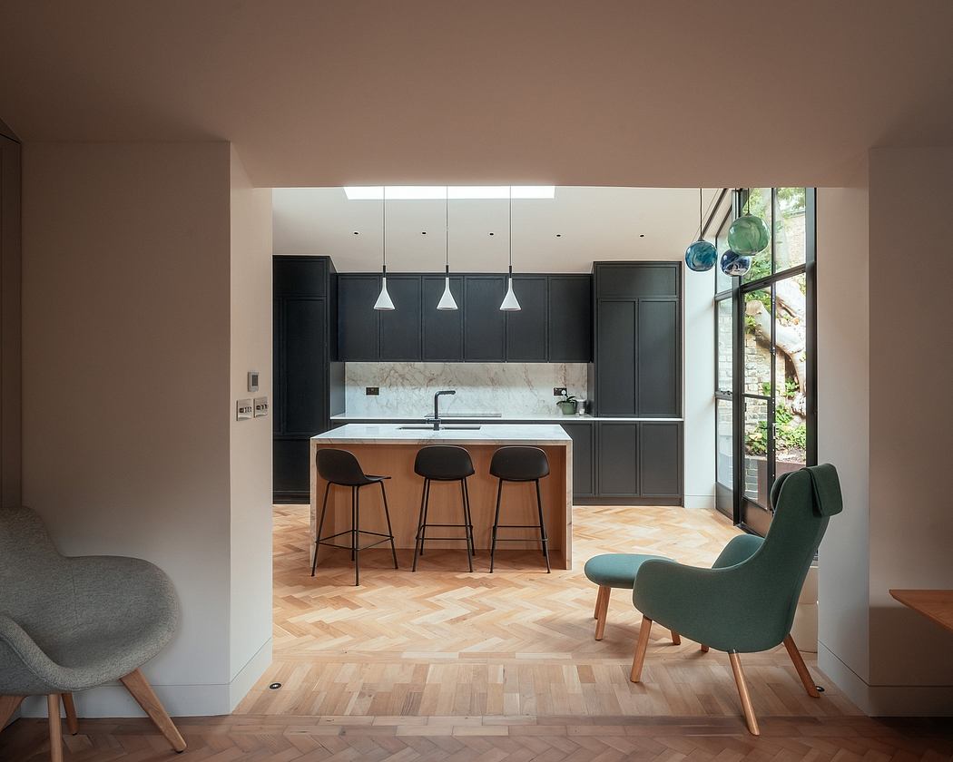 Stunning contemporary kitchen with sleek black cabinetry, marble countertops, and wood flooring.