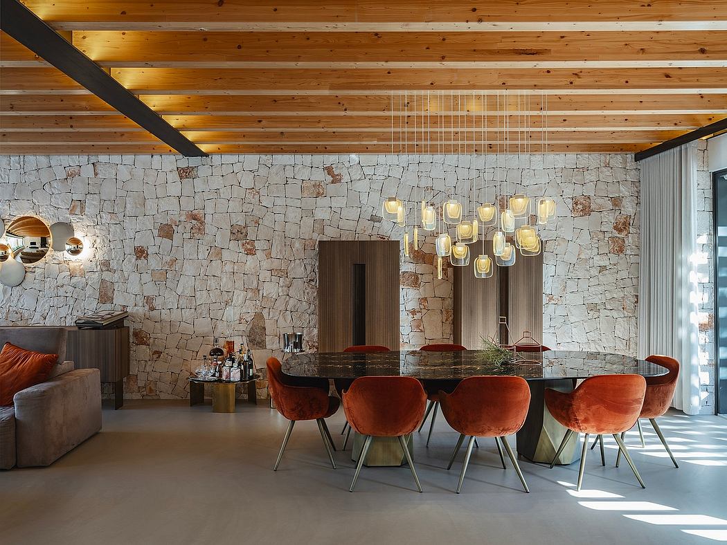 Rustic dining room with stone feature wall, wooden ceiling beams, and modern pendant lights.