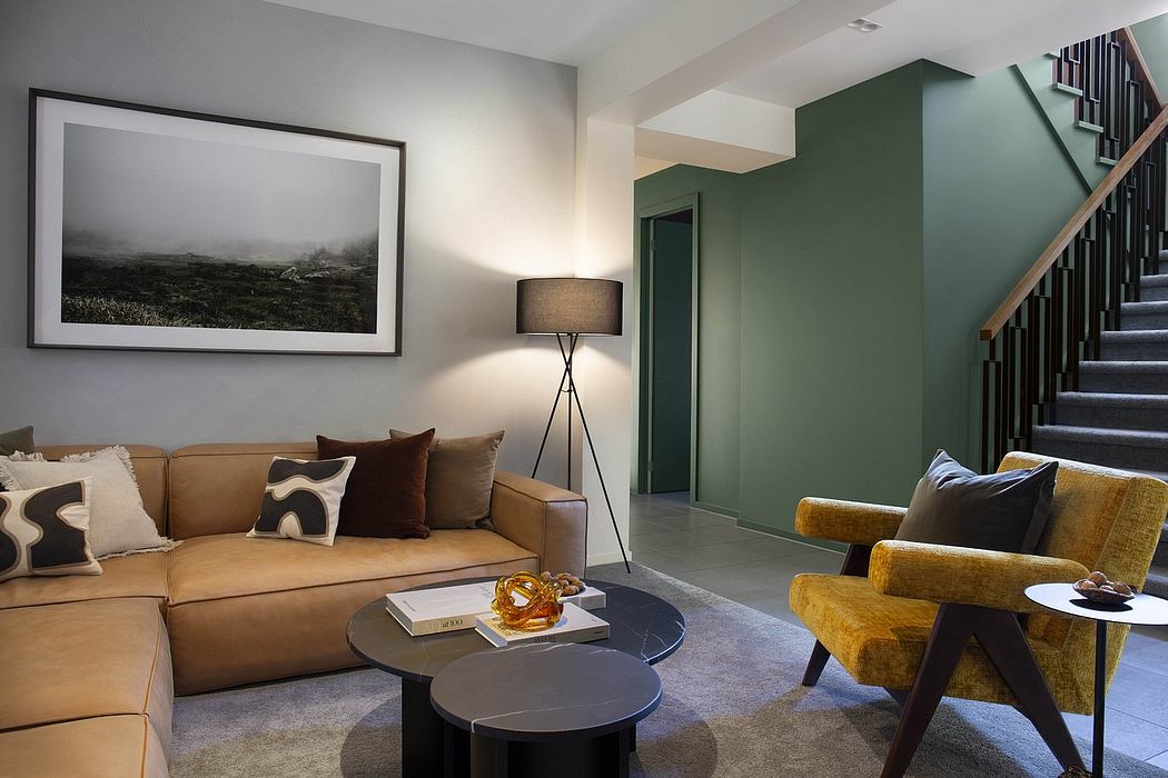 A modern living room with a sofa, chairs, and a framed artwork on the wall.