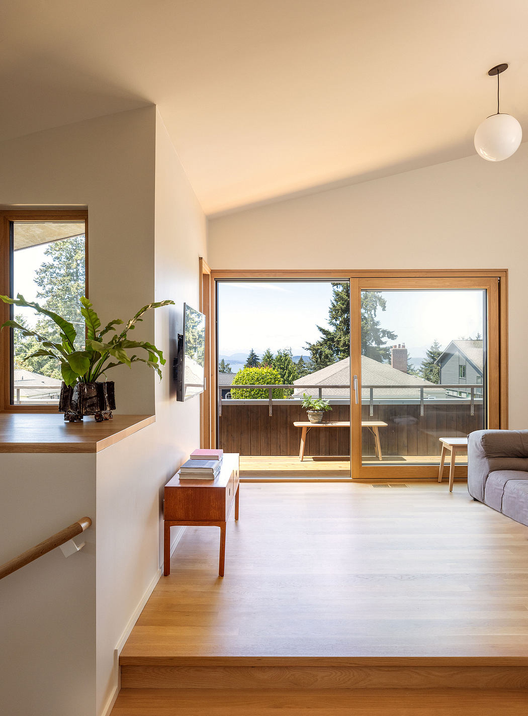 Bright, open-plan living space with large windows overlooking natural scenery.