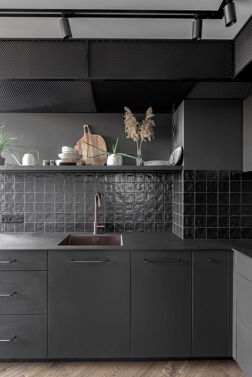 Modern, minimalist kitchen with black cabinetry, tiled backsplash, and shelving display.