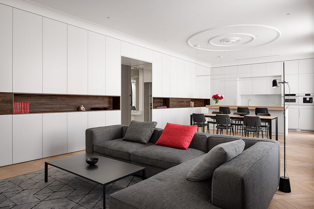 Minimalist living room with sleek white cabinetry, wooden accents, and a modern sectional sofa.