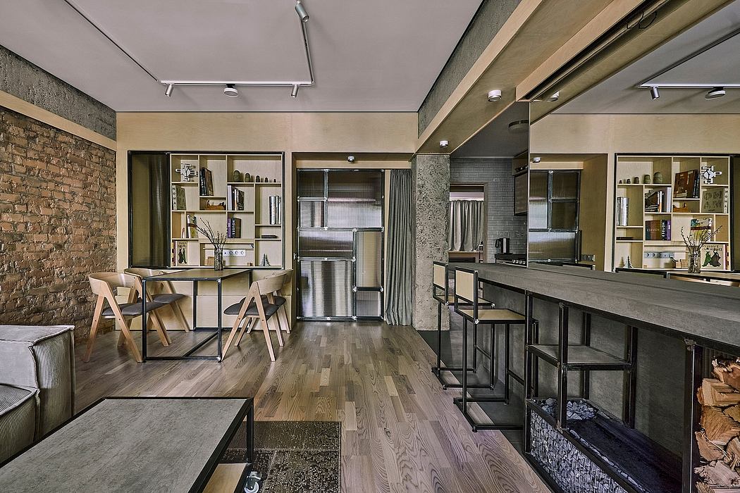 Spacious loft-style kitchen and dining area with exposed brick walls, wooden floors, and modern furnishings.