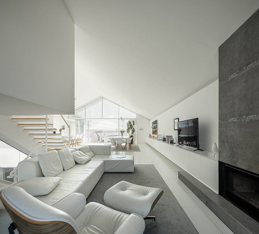 Modern, minimalist living room with white furniture, sleek cabinetry, and a striking concrete accent wall.