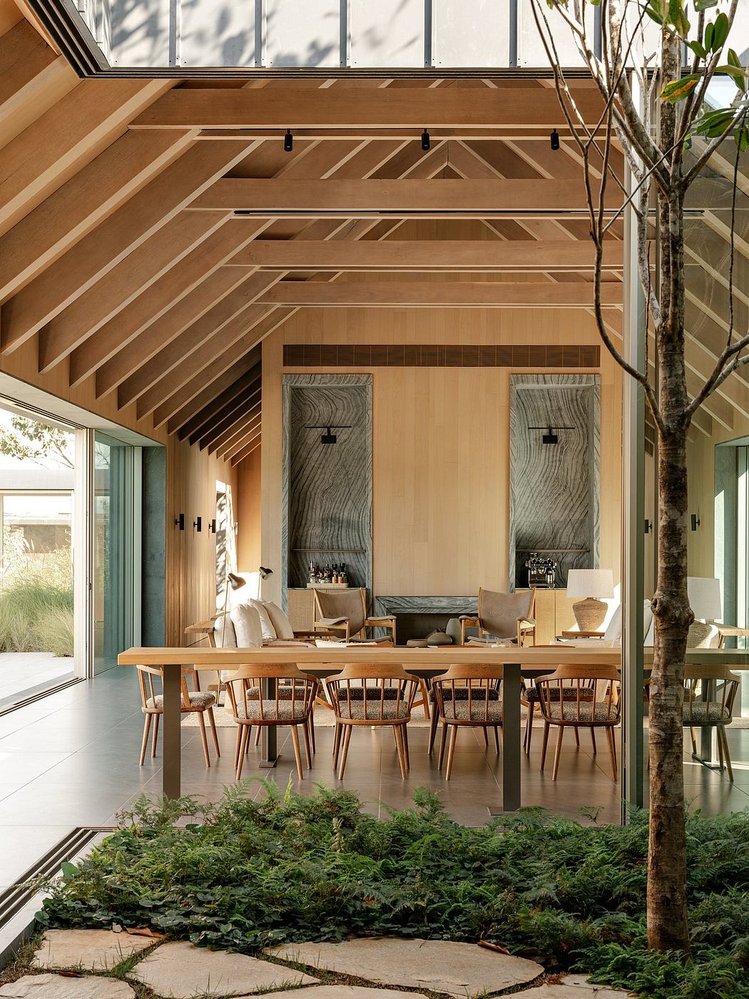 Stunning wooden beams and panels, large windows, and integrated greenery create a harmonious modern interior.