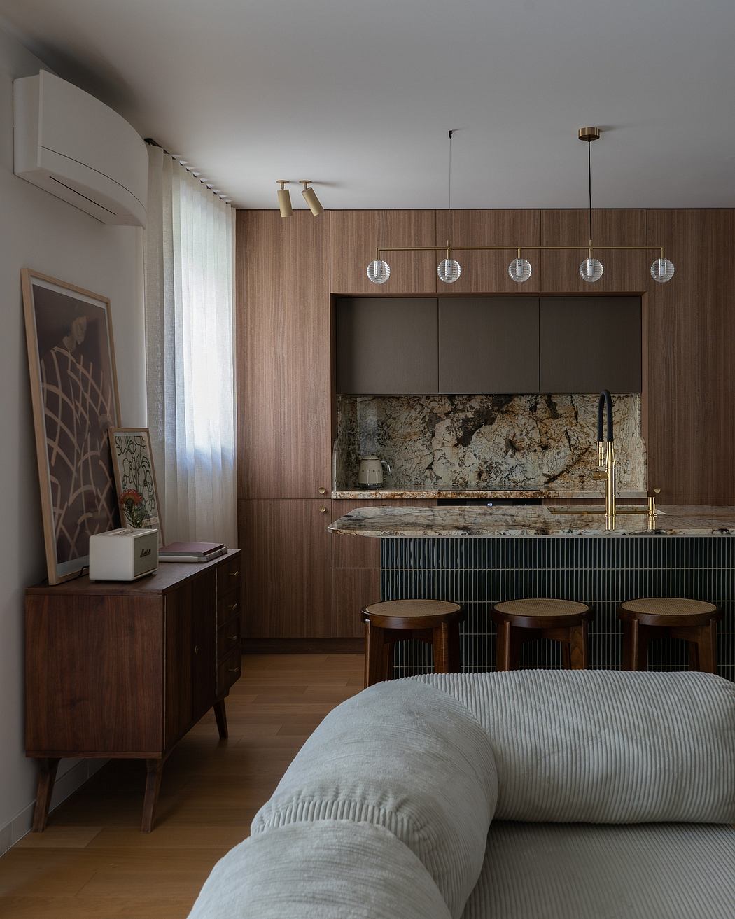 A modern kitchen with wood paneling, pendant lighting, and a granite countertop.