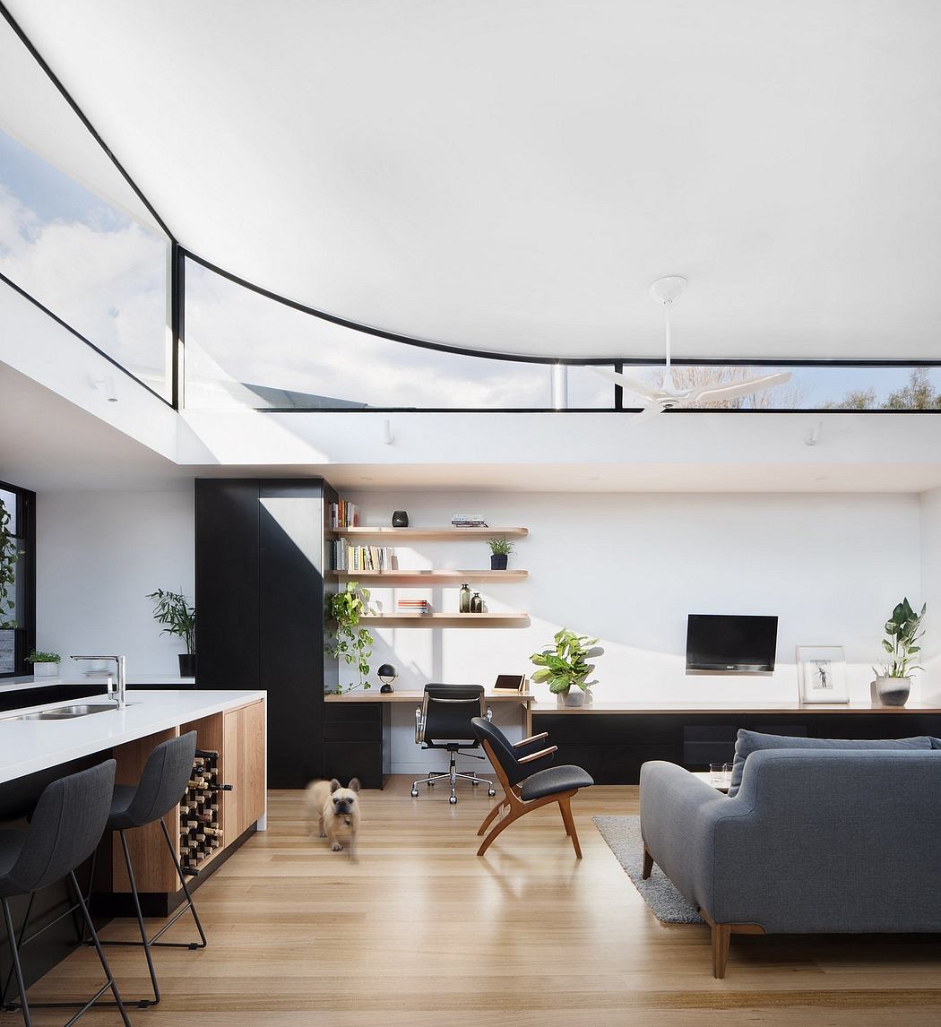 Modern, open-concept living room with sleek, minimalist furnishings and large windows.