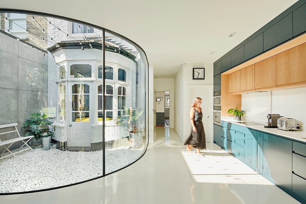 Modern kitchen with arched windows, sleek cabinets, and an indoor courtyard.