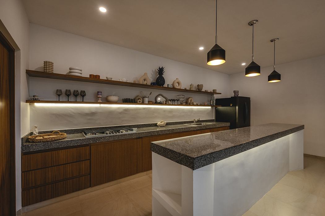 Modern kitchen with natural wood cabinets, marble countertops, and pendant lighting.