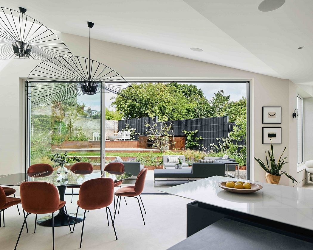 Sleek modern interior with large windows overlooking a lush garden, black and tan furnishings.