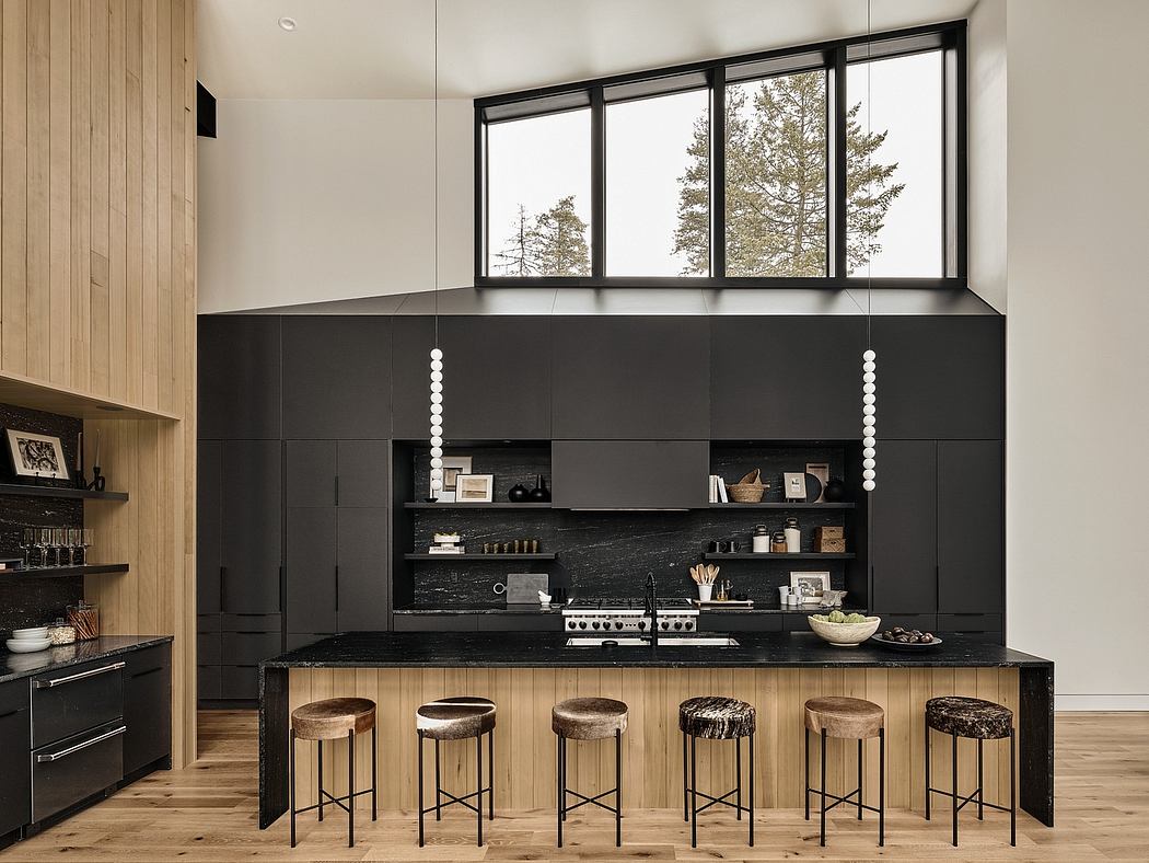 Modern kitchen with black cabinetry, wood accents, and large windows offering scenic views.