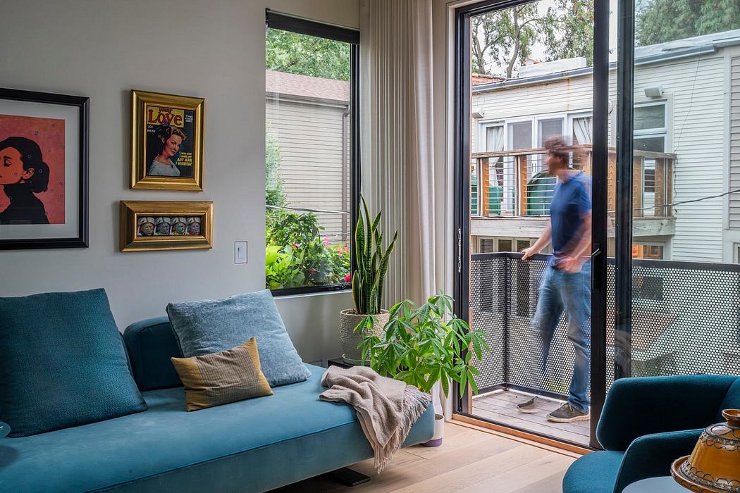 Cozy living room with floor-to-ceiling windows, plush blue sofa, and framed artwork.