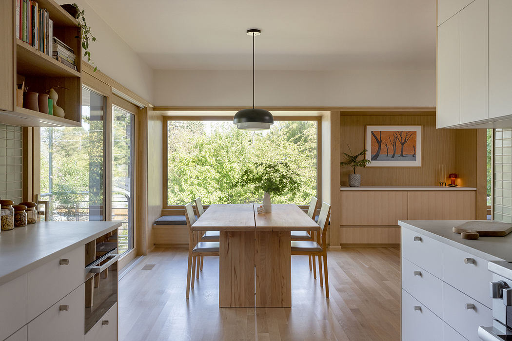A cozy kitchen and dining area with wood furnishings and natural light from large windows.
