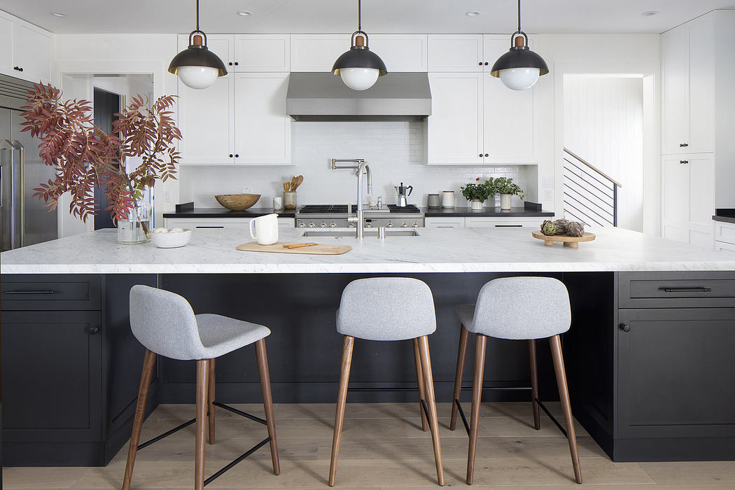 Sleek, modern kitchen with black and white cabinets, pendant lighting, and a stylish island with barstools.