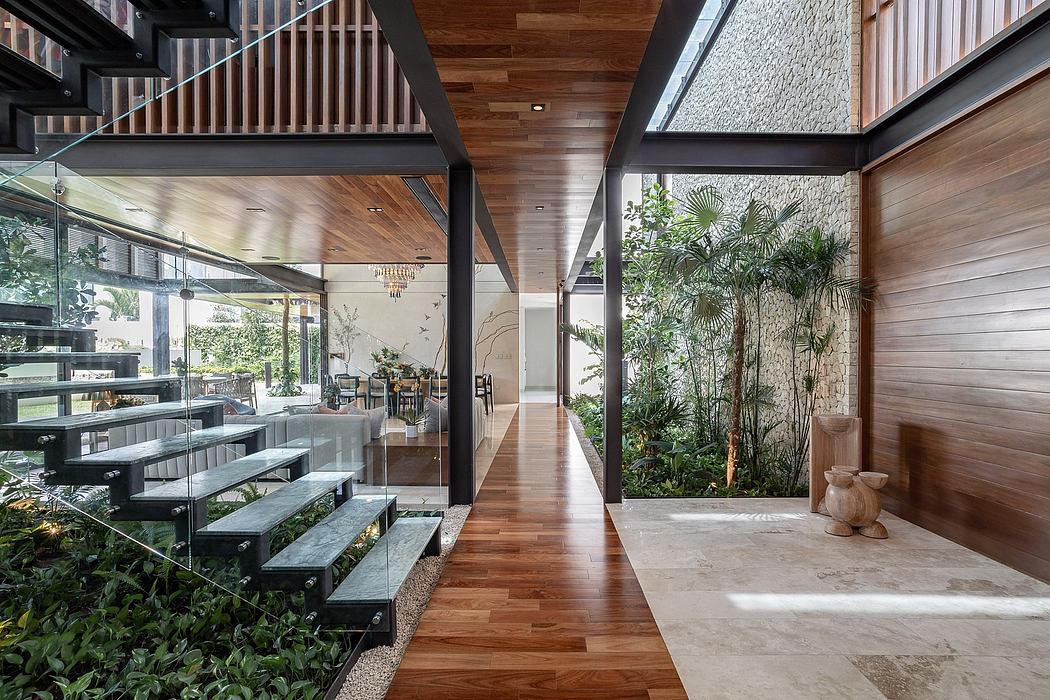 Spacious open-concept interior with wood paneling, glass walls, and lush indoor foliage.