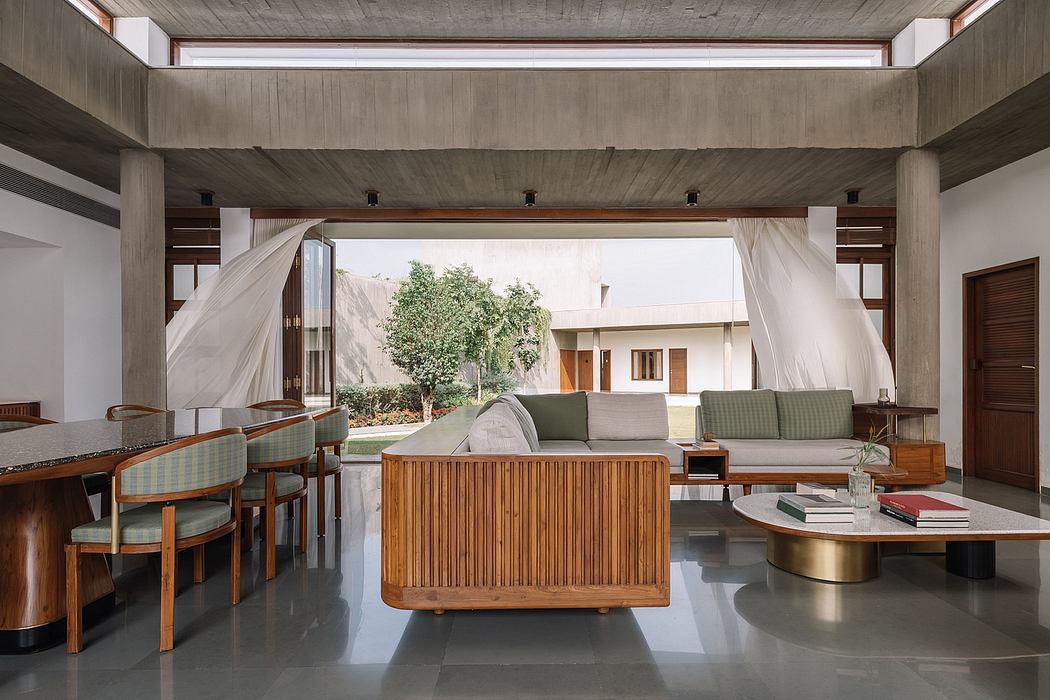 Spacious, modern lounge with concrete ceiling, wood accents, and lush outdoor views.