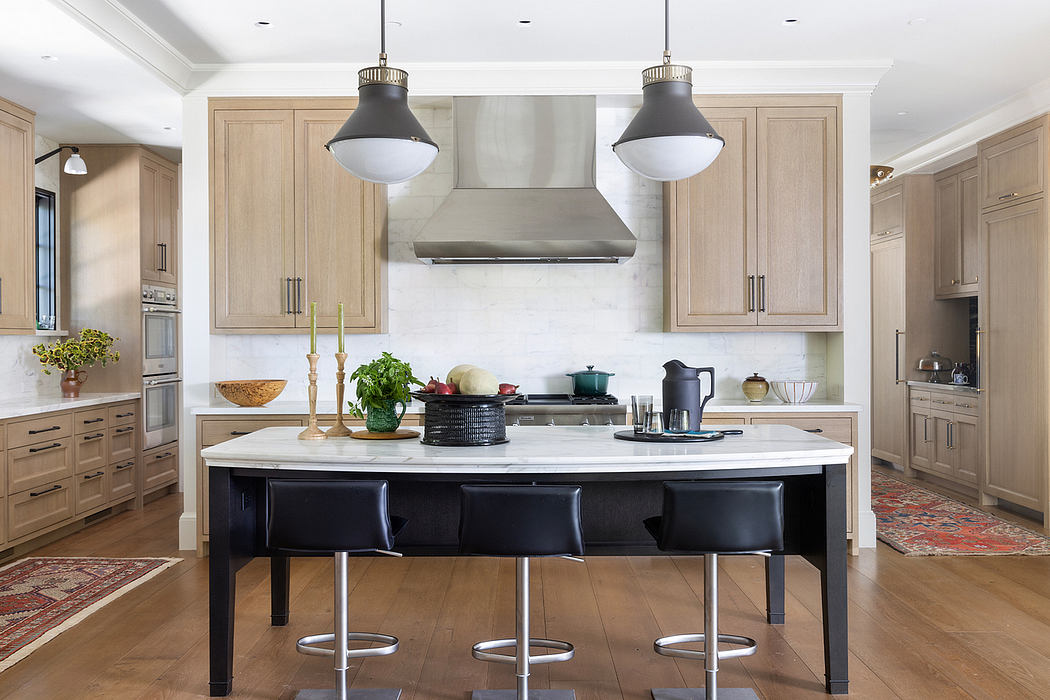 Spacious, light-filled kitchen with neutral cabinetry, marble countertops, and a large central island.