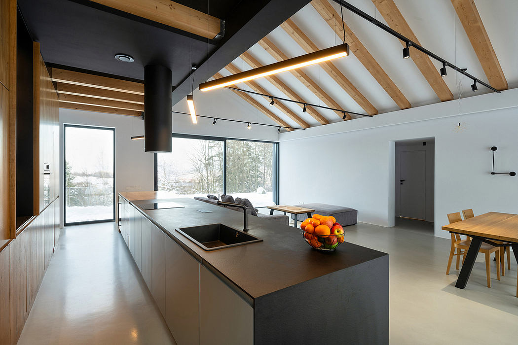 Sleek modern kitchen with wooden ceiling beams, large windows, and contemporary furnishings.