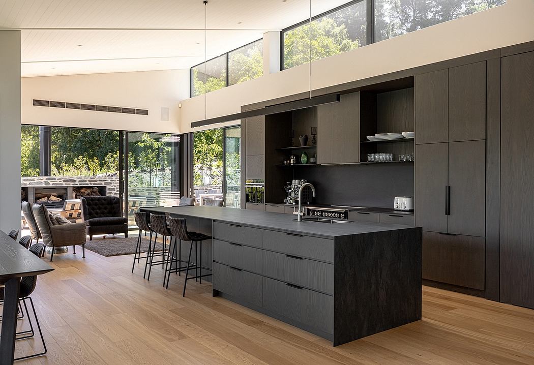 Sleek modern kitchen with black minimalist cabinetry, large windows, and wooden flooring.