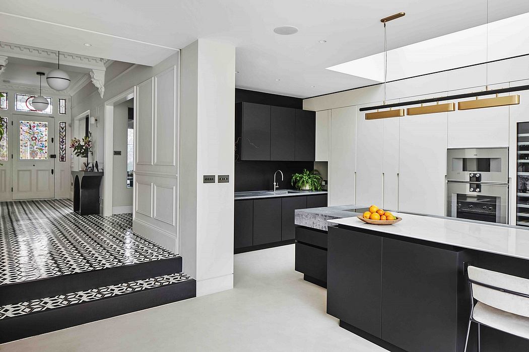 Sleek, modern kitchen with black and white cabinetry, marble countertop, and geometric floor tiles.