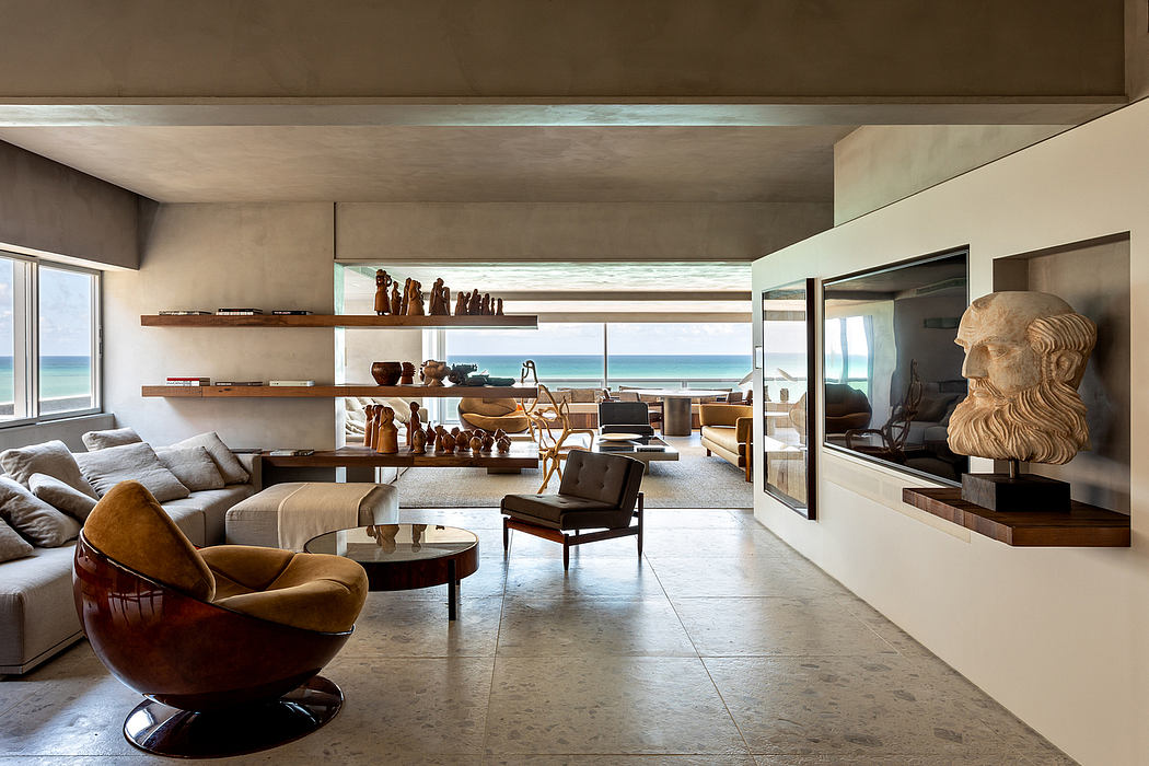 Spacious modern living room with large windows, shelves, and sculpted artworks.
