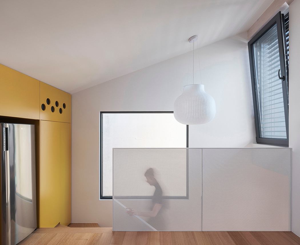 A modern, minimalist interior design with a white pendant lamp and yellow accents.