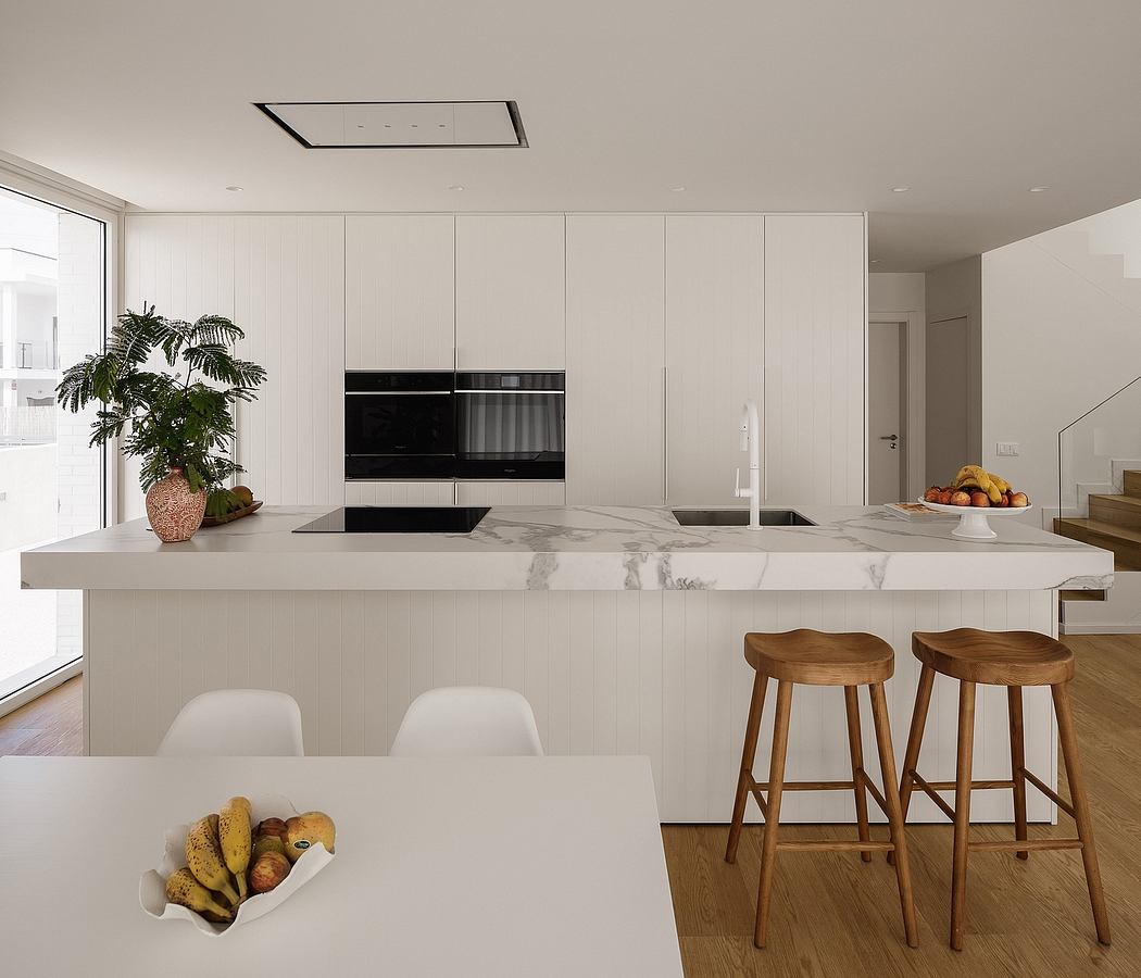 Sleek, minimalist kitchen with white cabinets, marble countertops, and wood stools.