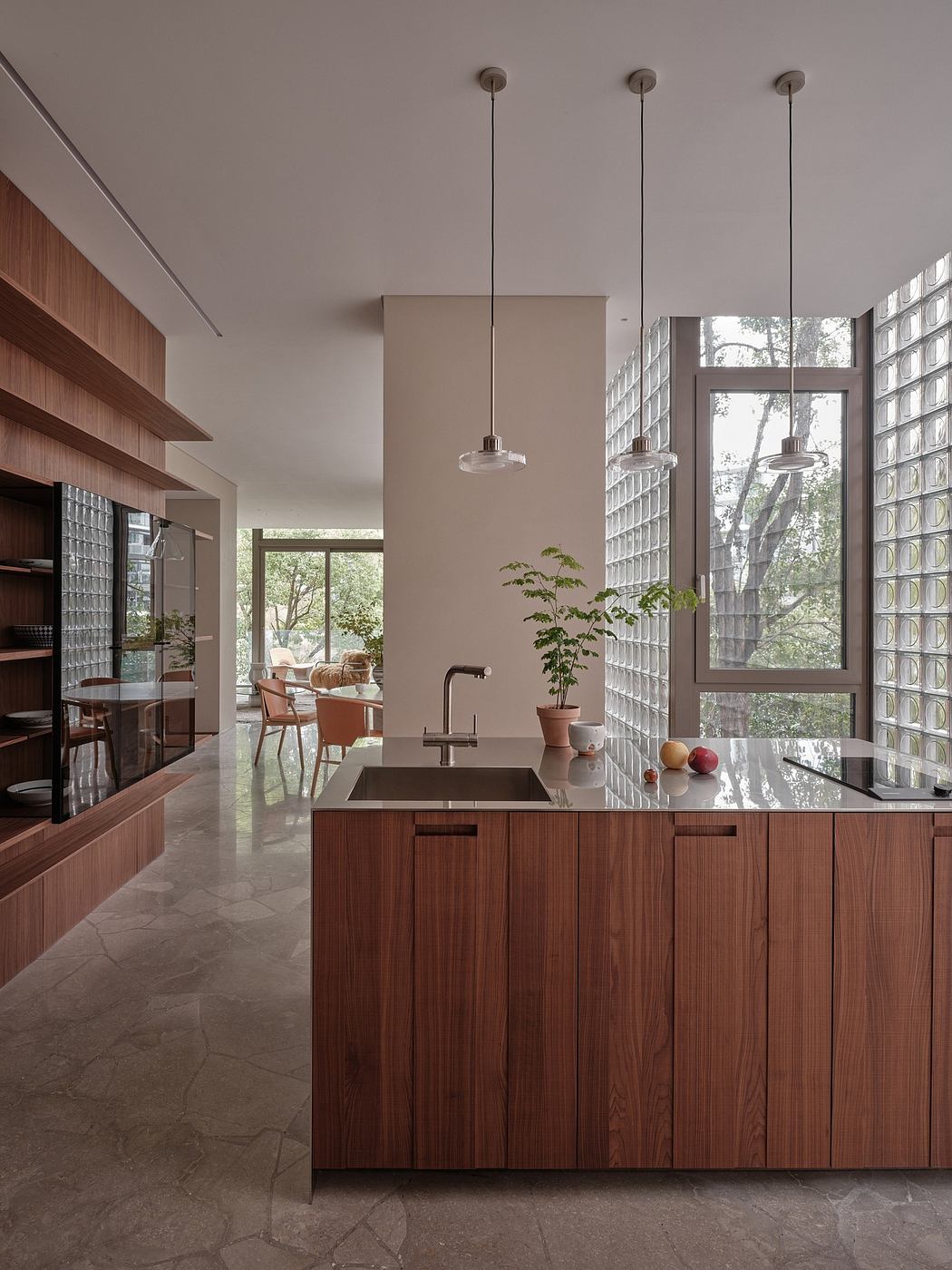 Sleek, modern kitchen with warm wood cabinetry, pendant lights, and expansive windows.