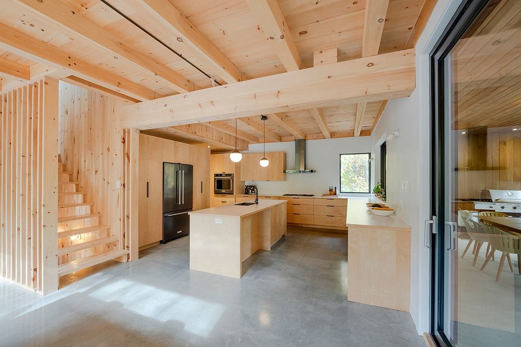 Modern, wood-paneled kitchen with sleek white countertops, pendant lighting, and open floor plan.