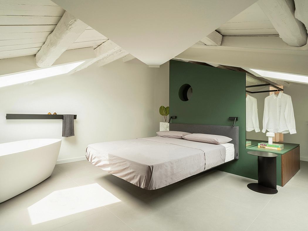 Minimalist bedroom design with sloped ceilings, dark green accent wall, and a modern platform bed.