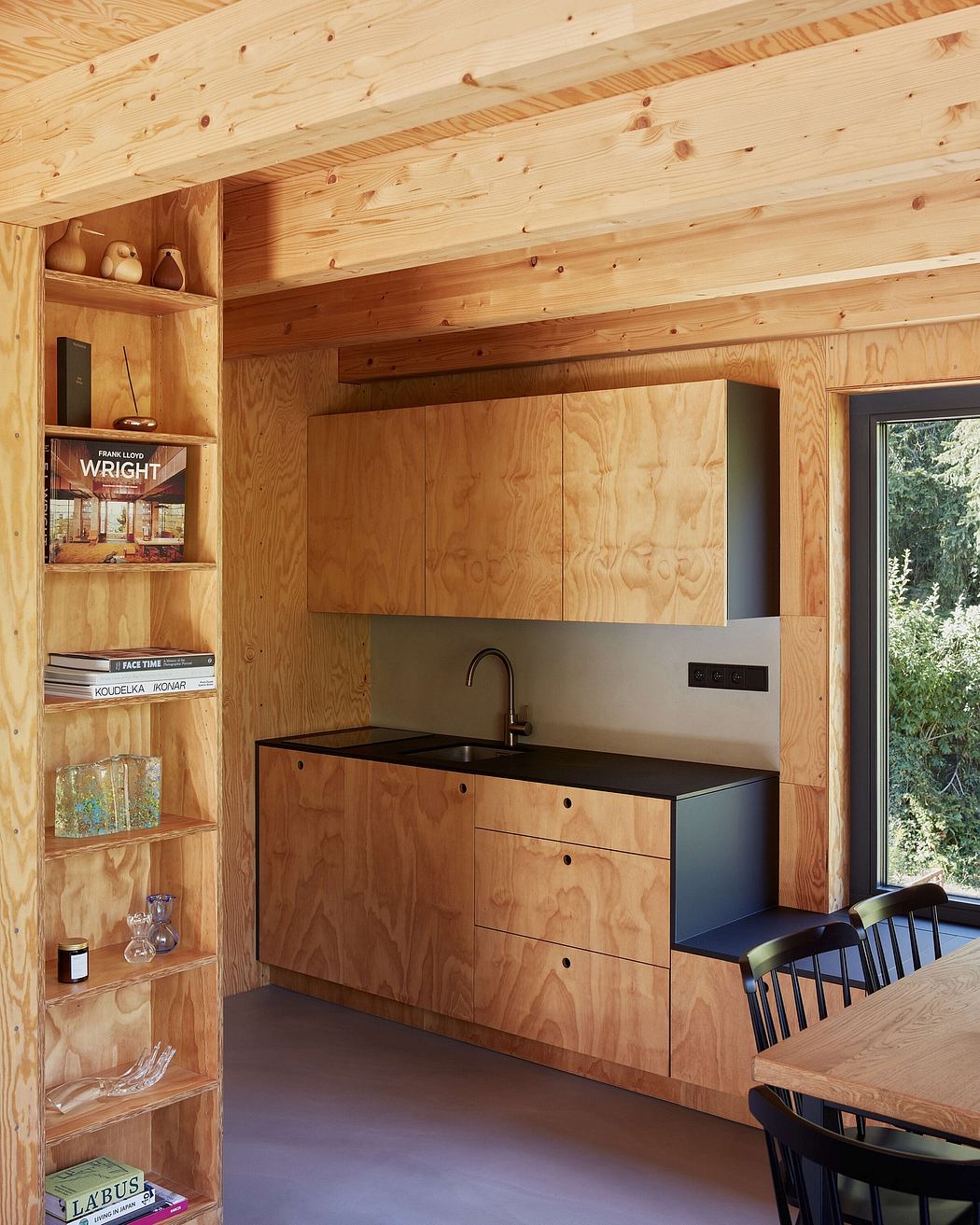 Rustic wooden cabin interior with minimalist kitchen cabinetry and shelving.