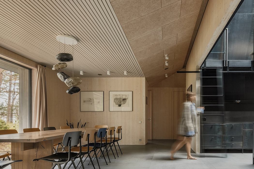 Warm-toned interior with wooden paneled walls, built-in shelving, and modern dining furniture.