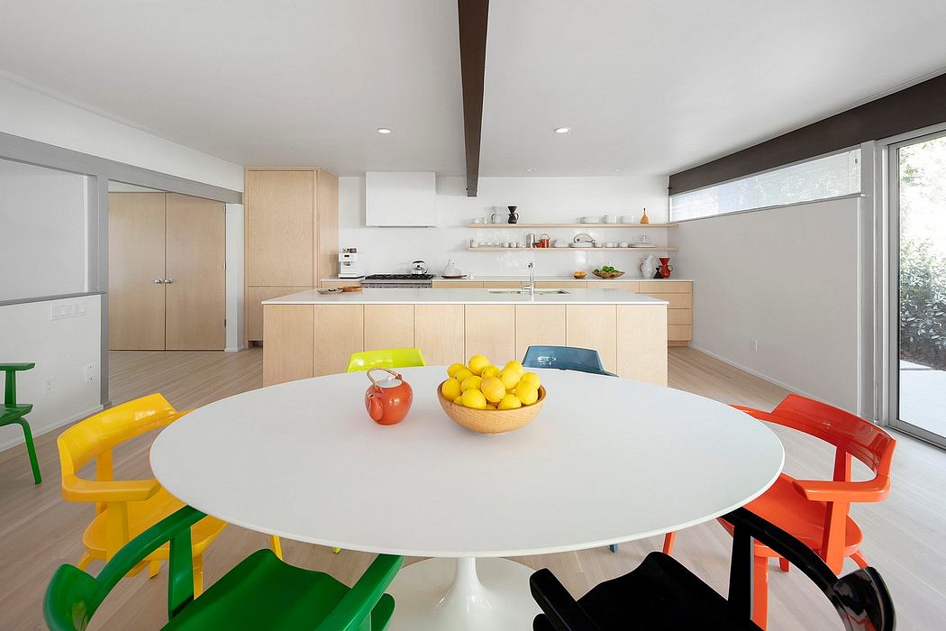 Bright, modern kitchen with a large round dining table and colorful seating.