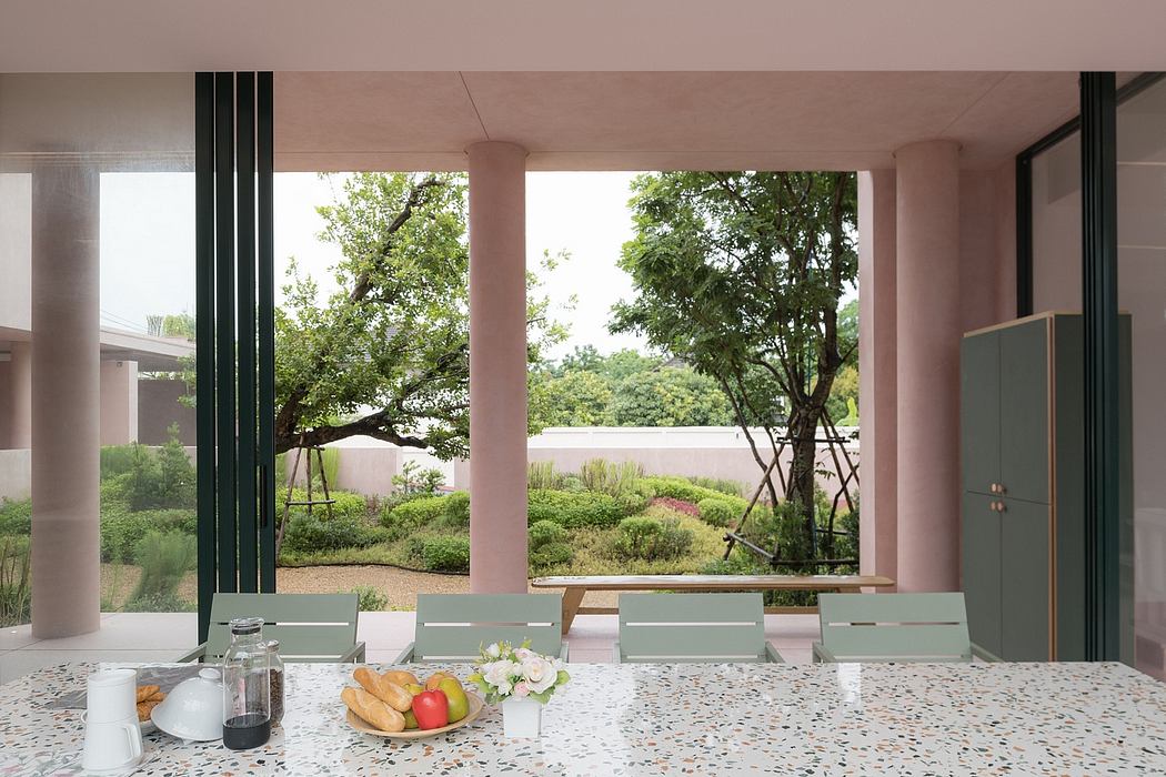 Spacious dining room with floor-to-ceiling windows showcasing lush greenery outside.