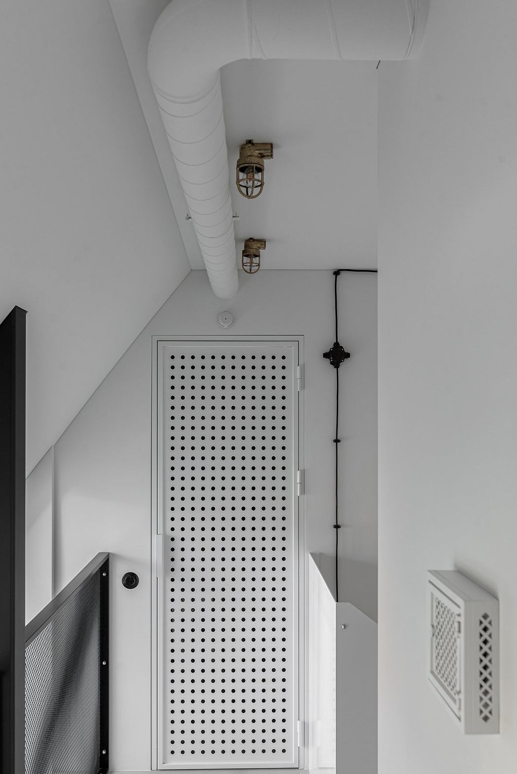 A minimalist interior design featuring geometric patterns, metal fixtures, and white walls.