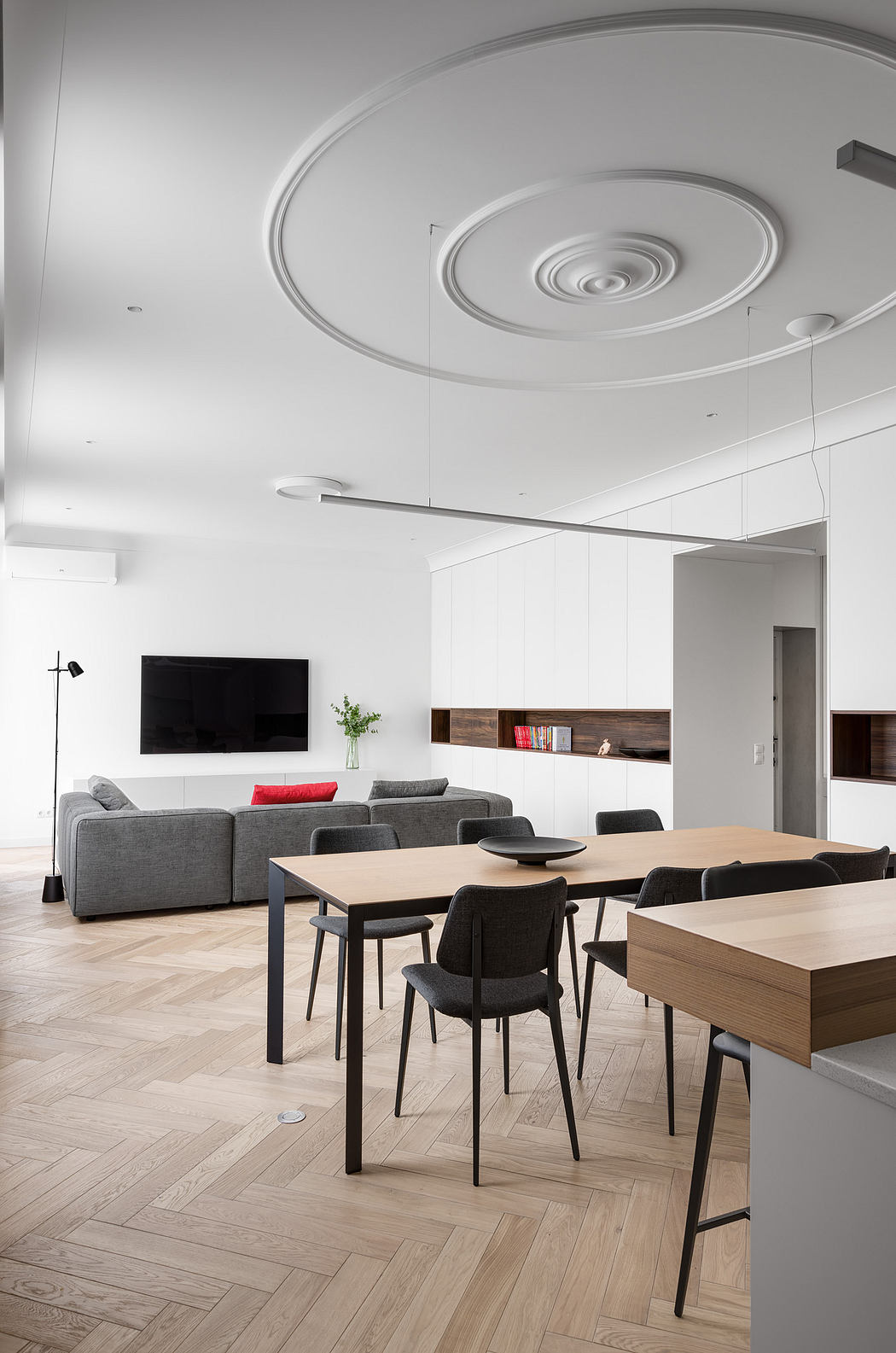 Modern, minimalist living room with circular lighting fixtures, wood and black furnishings.