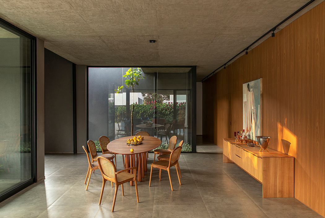 Spacious modern dining area with wooden furnishings, floor-to-ceiling windows, and a potted plant.