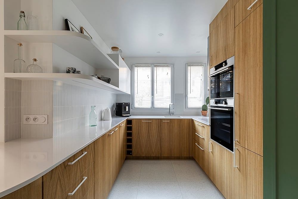Modern kitchen with minimalist design, wooden cabinets, and built-in shelving.