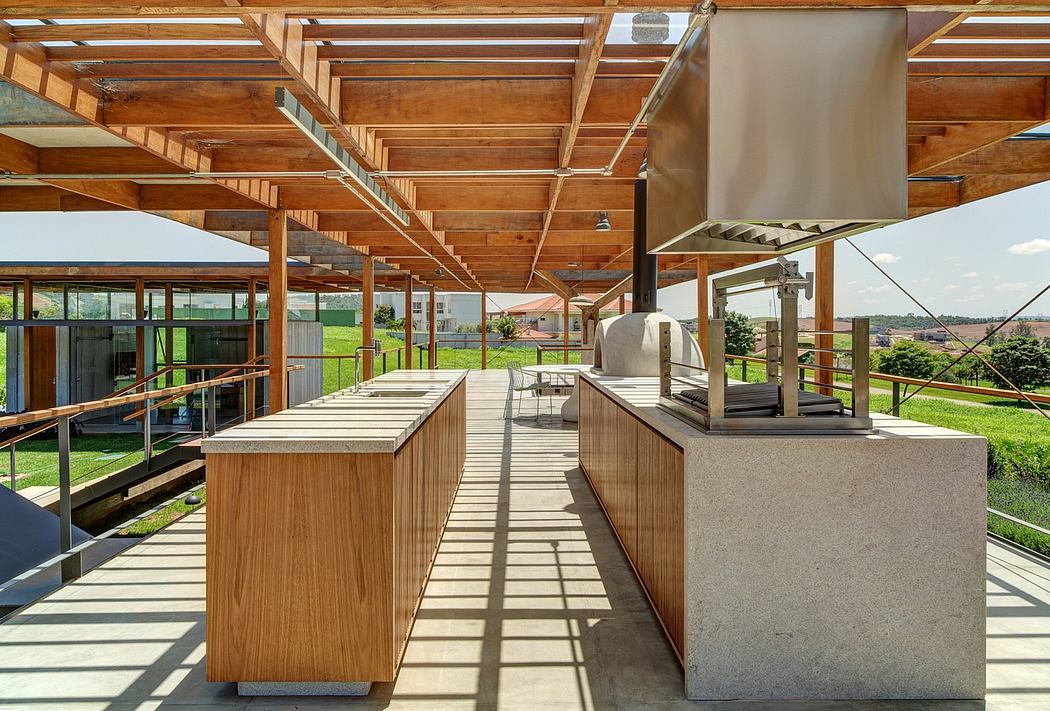 Spacious wooden terrace with modern kitchen appliances and sweeping countryside views.