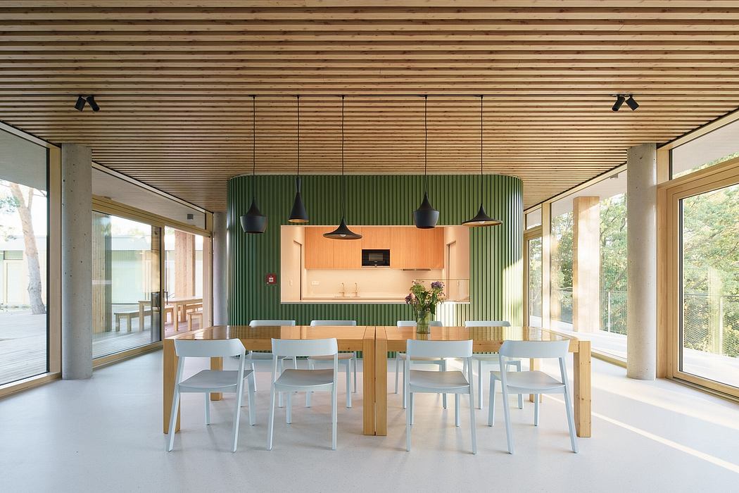 Bright, modern dining area with wooden slat ceiling, green accent wall, and pendant lighting.